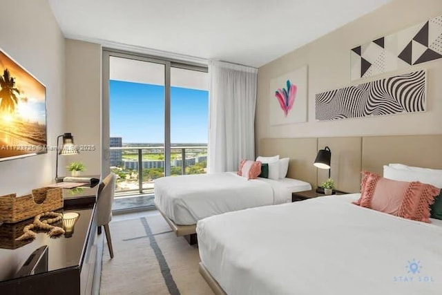 bedroom featuring access to exterior, multiple windows, and floor to ceiling windows