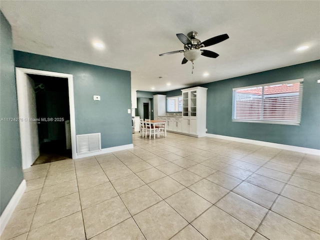 unfurnished living room with ceiling fan and light tile patterned flooring