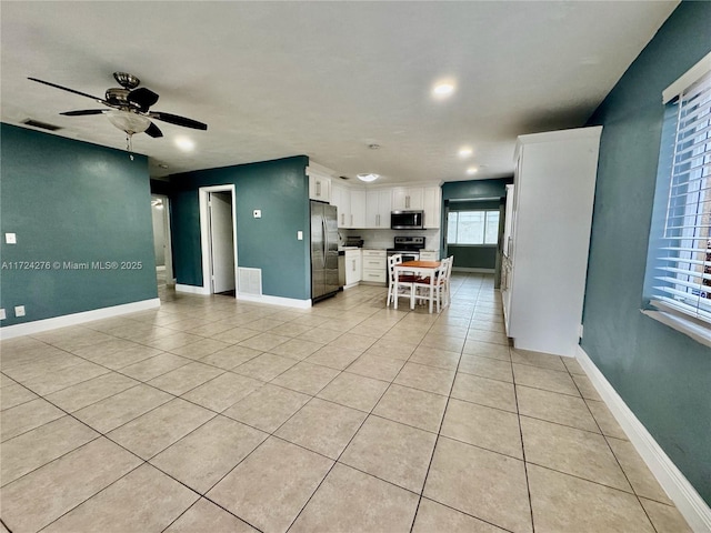 kitchen featuring ceiling fan, light tile patterned flooring, white cabinetry, and stainless steel appliances