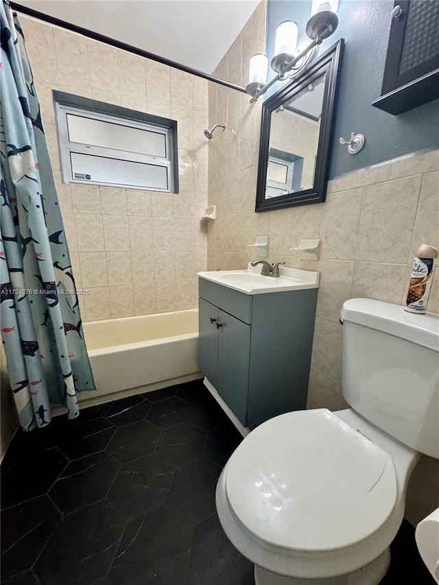 full bathroom featuring tile patterned flooring, toilet, shower / tub combo with curtain, vanity, and tile walls