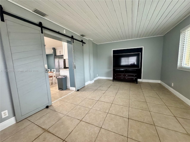 interior space with ornamental molding, a barn door, wooden ceiling, and light tile patterned flooring