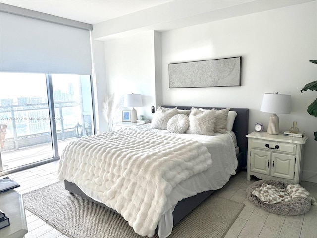 bedroom featuring access to outside, light hardwood / wood-style flooring, and expansive windows