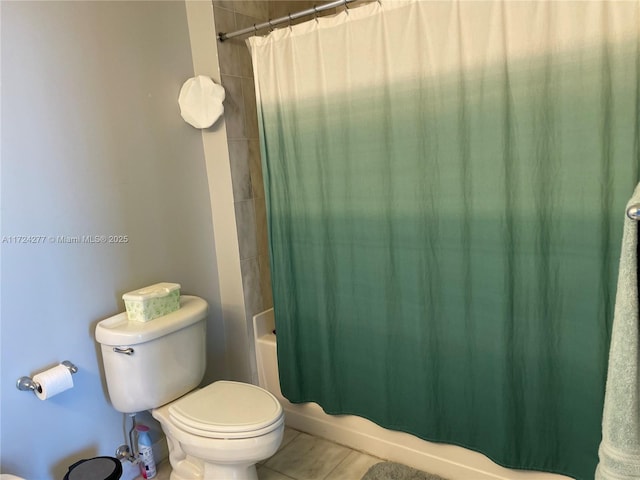 bathroom featuring tile patterned flooring, toilet, and shower / tub combo with curtain