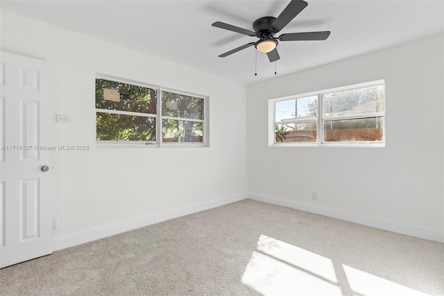 carpeted empty room with ceiling fan and plenty of natural light