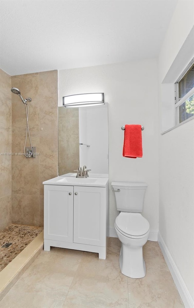 bathroom featuring tiled shower, vanity, and toilet