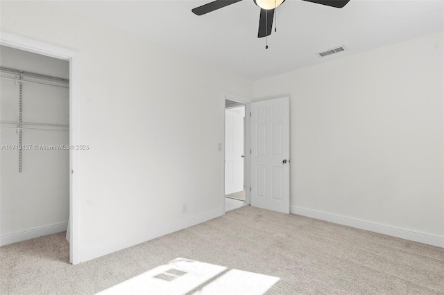 unfurnished bedroom with ceiling fan, a closet, and light carpet