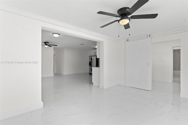 empty room with ceiling fan, a barn door, and ornamental molding