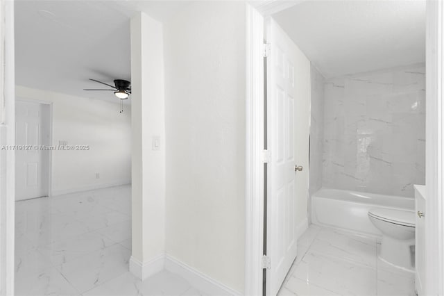 bathroom with bathtub / shower combination, toilet, and ceiling fan