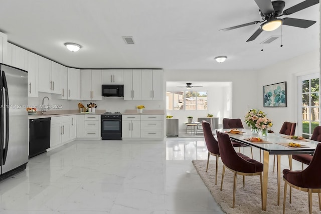 kitchen with white cabinetry, sink, ceiling fan, and black appliances