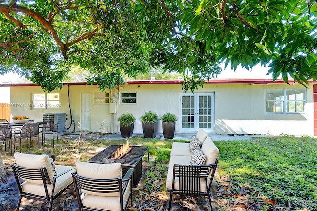 back of property featuring french doors, an outdoor living space with a fire pit, and central AC unit