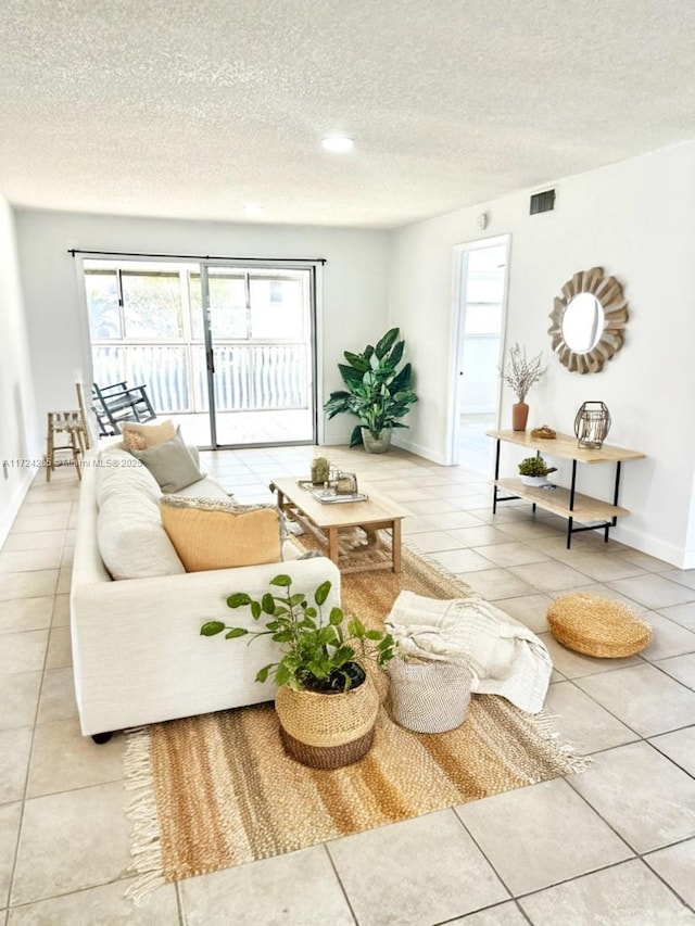 tiled living room featuring a textured ceiling