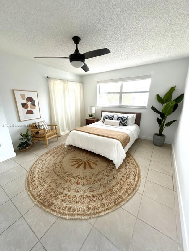 bedroom featuring a textured ceiling, tile patterned floors, and ceiling fan