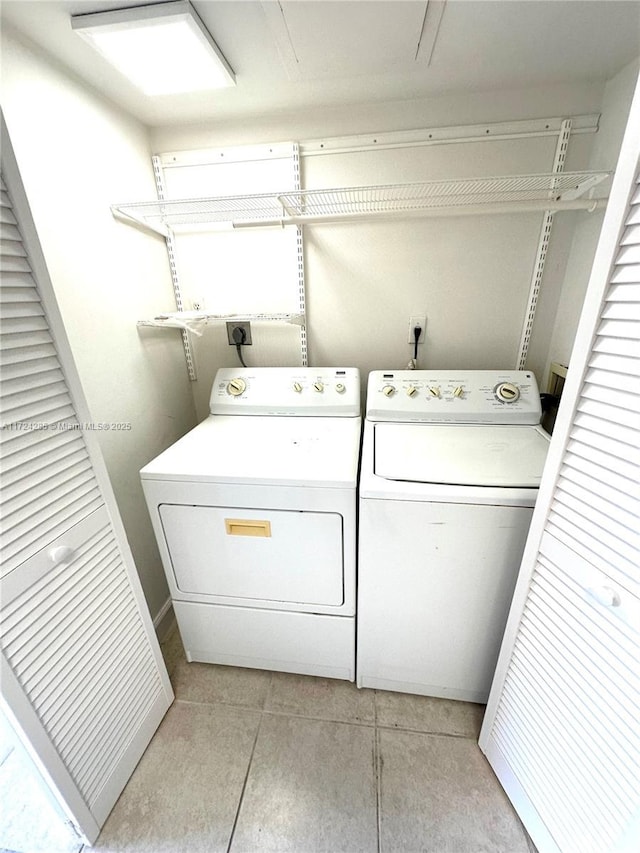 washroom featuring washer and clothes dryer and light tile patterned floors