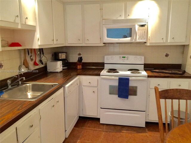 kitchen with white cabinetry, sink, and white appliances