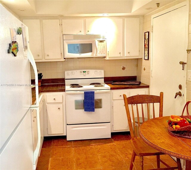 kitchen with white cabinetry, white appliances, and tasteful backsplash