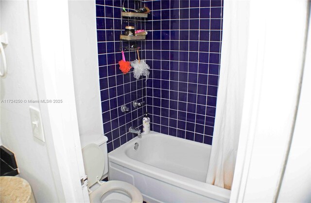 bathroom featuring shower / tub combo with curtain and toilet