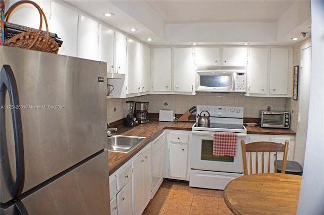 kitchen featuring white cabinetry, sink, white appliances, and decorative backsplash