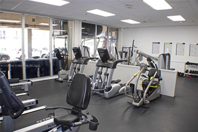 exercise room with plenty of natural light and a drop ceiling