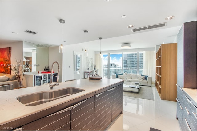 kitchen with sink, decorative light fixtures, and light tile patterned floors