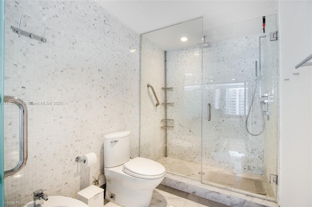 bathroom featuring tile patterned flooring, a shower with door, tile walls, toilet, and a bidet