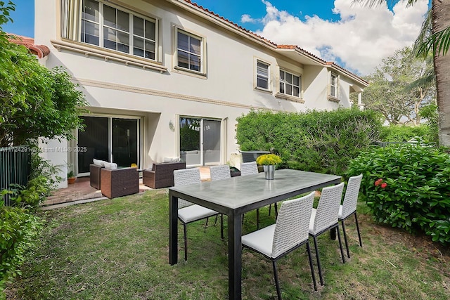 rear view of property featuring a yard, outdoor lounge area, and a patio