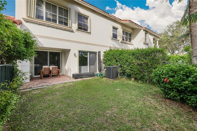 back of house featuring a yard, central AC unit, and a patio area