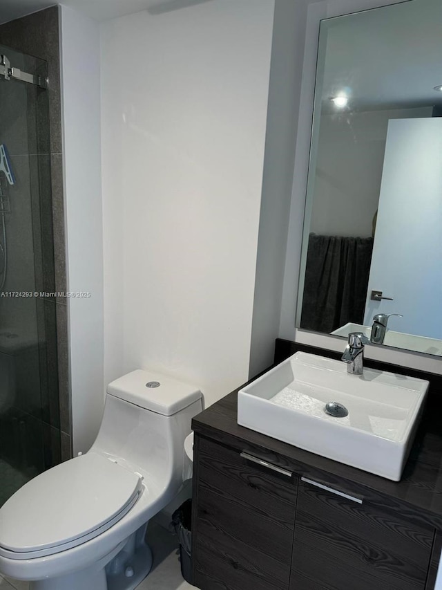 bathroom featuring vanity, toilet, and a shower with shower door