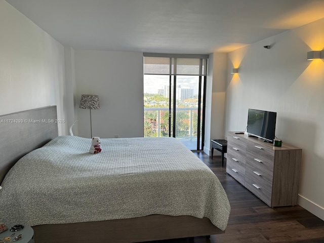 bedroom featuring dark hardwood / wood-style flooring and a wall of windows