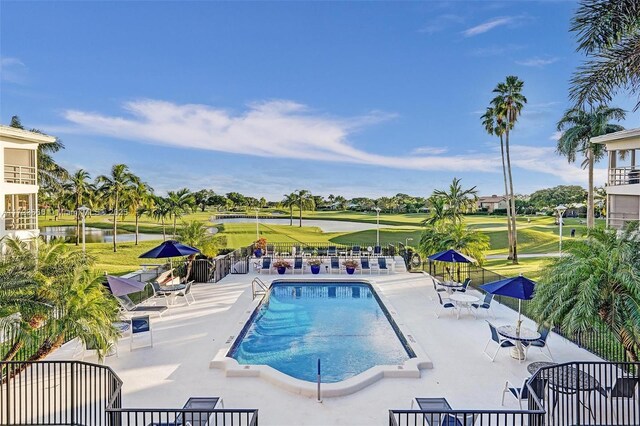 view of swimming pool featuring a yard and a water view