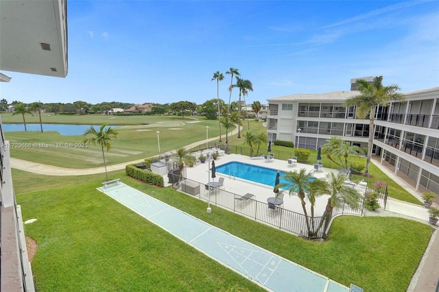 pool featuring view of golf course, a water view, fence, a lawn, and shuffleboard