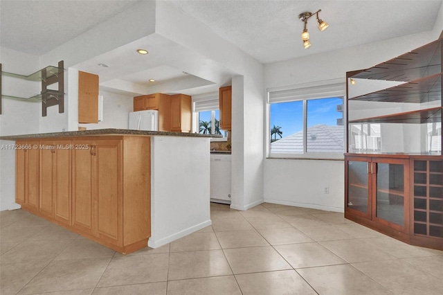 kitchen featuring light tile patterned floors, recessed lighting, dark stone counters, white appliances, and baseboards