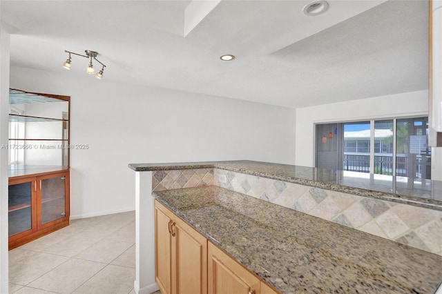 4848 NE 23rd Ave Unit 2C, Fort Lauderdale, FL 33308 - kitchen featuring dark stone counters, recessed lighting, light tile patterned flooring, light brown cabinets, and backsplash