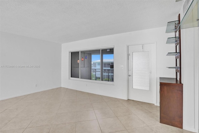 spare room featuring a textured ceiling and tile patterned floors