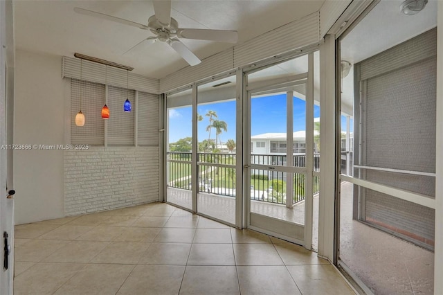 unfurnished sunroom with ceiling fan