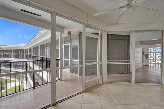 unfurnished sunroom featuring ceiling fan