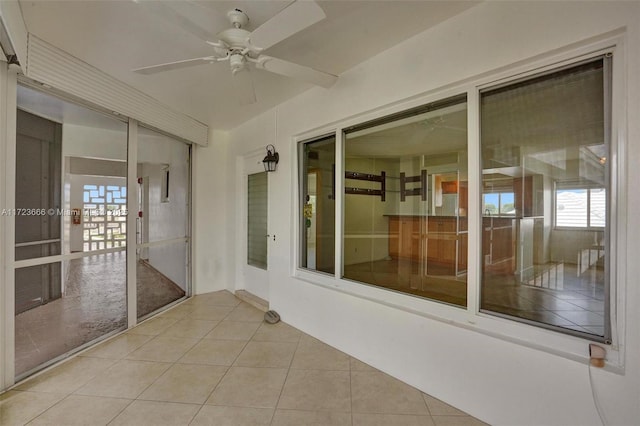 unfurnished sunroom with ceiling fan