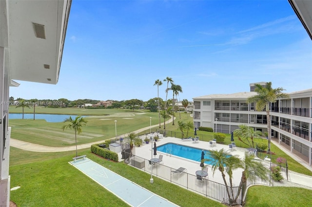 pool with shuffleboard, a water view, fence, a yard, and view of golf course