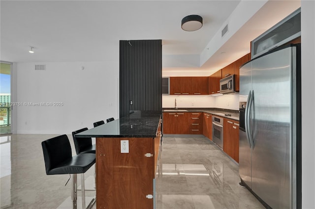 kitchen with backsplash, a breakfast bar, stainless steel appliances, sink, and a kitchen island