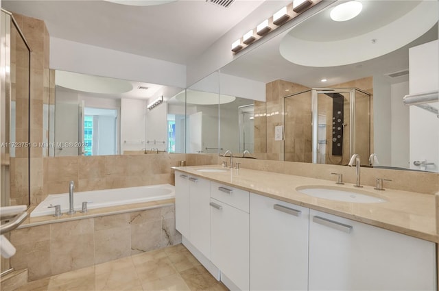 bathroom featuring vanity and independent shower and bath