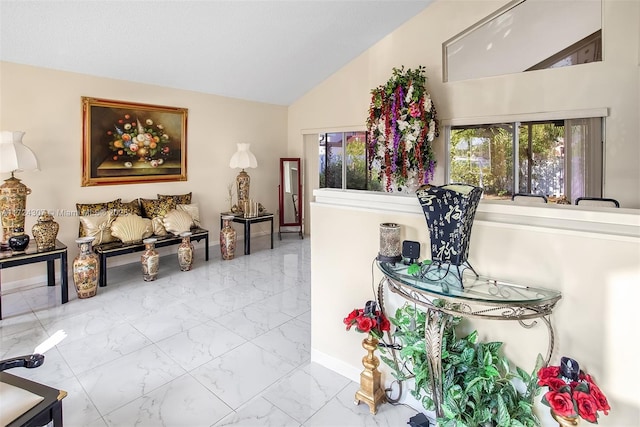 interior space with marble finish floor, vaulted ceiling, and baseboards