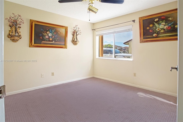 spare room with carpet floors, a textured ceiling, baseboards, and a ceiling fan