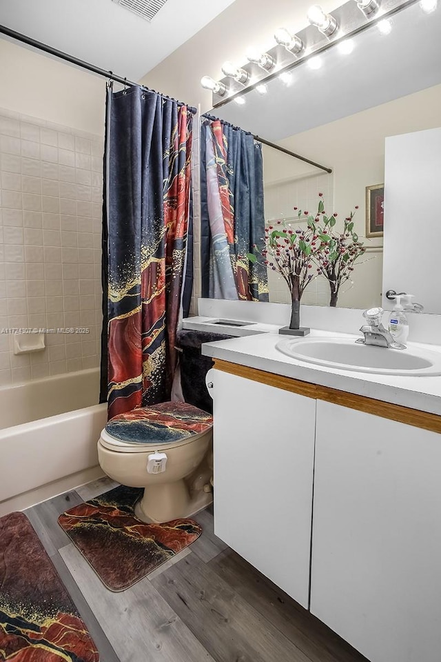 bathroom with toilet, wood finished floors, visible vents, vanity, and shower / bath combo with shower curtain