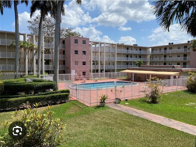 view of swimming pool with a yard