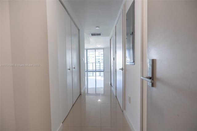 corridor featuring expansive windows and light tile patterned floors