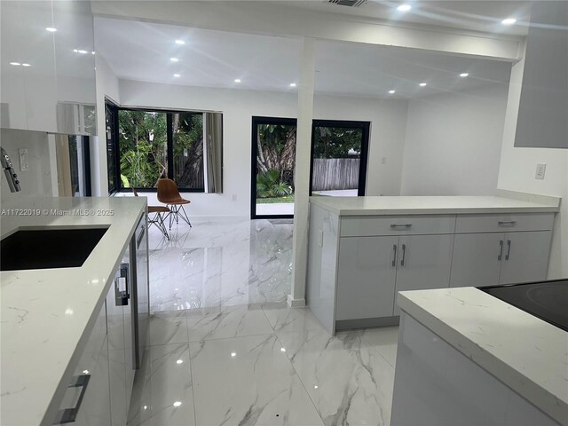 kitchen with backsplash, white cabinetry, sink, and stainless steel appliances