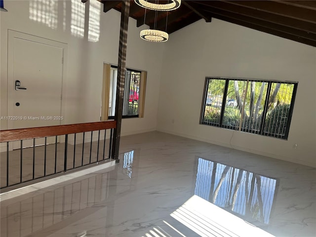 empty room featuring beamed ceiling and high vaulted ceiling