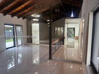 empty room featuring vaulted ceiling with beams and wood ceiling