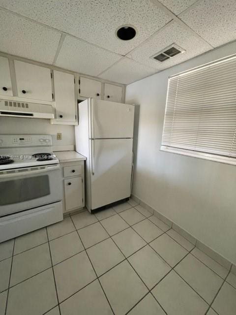 kitchen featuring white cabinets, a drop ceiling, white appliances, light tile patterned floors, and ventilation hood