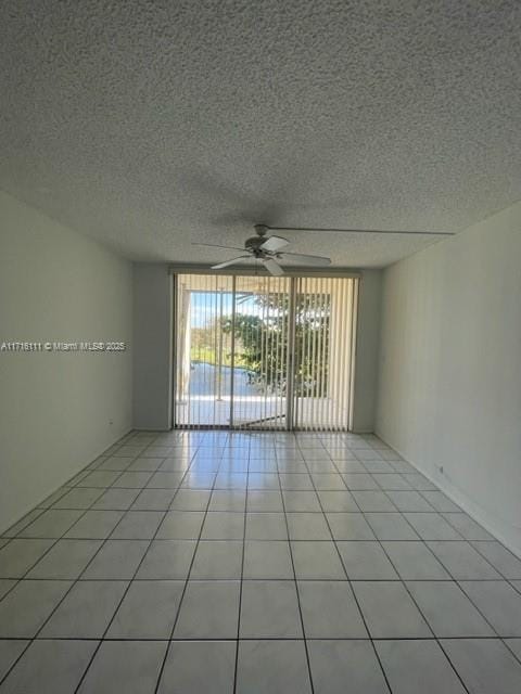 spare room featuring ceiling fan and light tile patterned floors