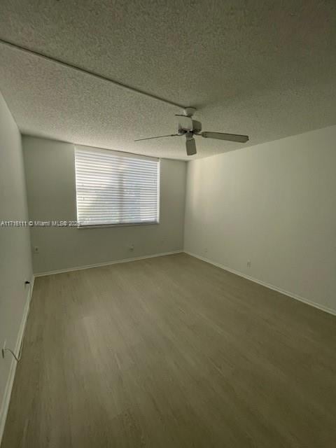 unfurnished room with a textured ceiling, ceiling fan, and wood-type flooring